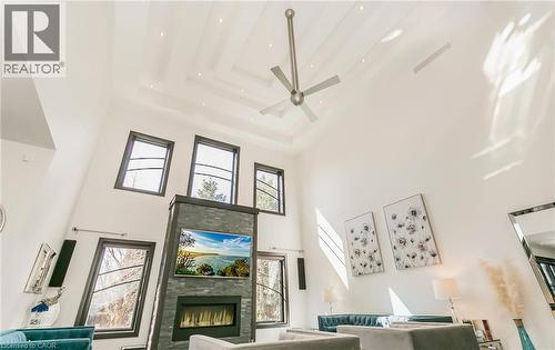 Living area featuring a tile fireplace, healthy amount of natural light, a high ceiling, and a ceiling fan - 24 Jacob Gingrich Drive, Kitchener, ON - Indoor Photo Showing Other Room With Fireplace