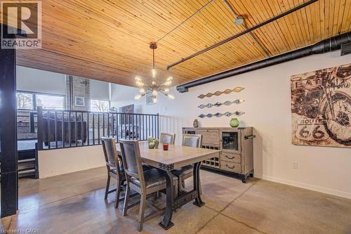 Dining space featuring finished concrete floors, wooden ceiling, and hanging lights - 85 Spruce Street Unit# 103, Cambridge, ON - Indoor Photo Showing Dining Room