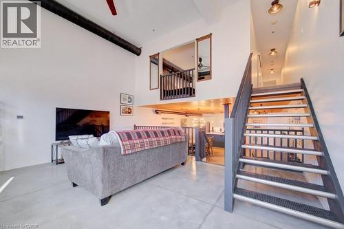Living area featuring finished concrete floors, a high ceiling, and ceiling fan - 85 Spruce Street Unit# 103, Cambridge, ON - Indoor Photo Showing Other Room