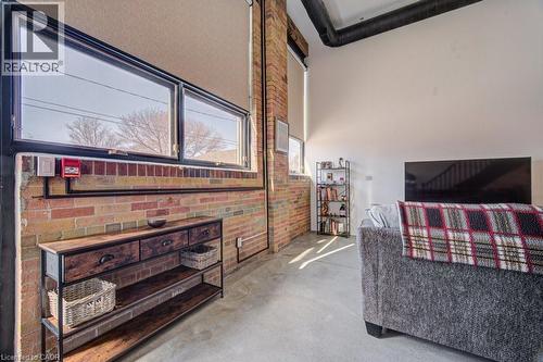 Bedroom with concrete flooring and brick wall - 85 Spruce Street Unit# 103, Cambridge, ON - Indoor