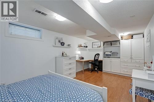Bedroom with a textured ceiling, light wood-style floors, and built in study area - 220 Townsend Avenue, Burlington, ON - Indoor Photo Showing Bedroom