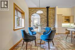 Dining room with stone tile floors, brick wall, and a wood stove - 