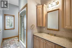Full bath with vanity, a stall shower, and stone finish flooring - 