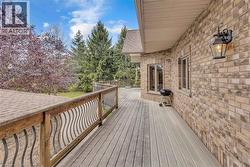 Expansive outdoor deck featuring wood-finish decking and decorative wood and metal railings - 