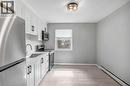 Kitchen featuring stainless steel appliances, white cabinets, baseboard heating, and light wood finished floors - 151 Siebert Avenue, Kitchener, ON  - Indoor Photo Showing Kitchen 