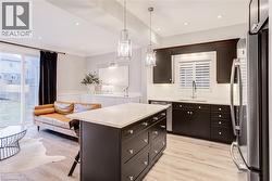 Kitchen featuring stainless steel appliances, a breakfast bar, open floor plan, a center island, and dark wood finish cabinets - 