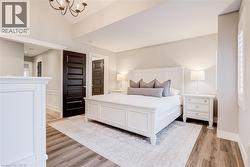 Bedroom featuring light wood-style floors and hanging lights - 