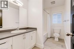 Bathroom with vanity, light wood finished floors, and shower / bath combo with shower curtain - 