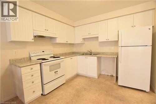 Kitchen with white appliances, white cabinets, and light countertops - 52 Meadowridge Street, Kitchener, ON - Indoor Photo Showing Kitchen With Double Sink