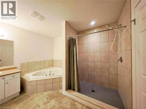 Full bath with a stall shower, vanity, a garden tub, and a textured ceiling - 52 Meadowridge Street, Kitchener, ON - Indoor Photo Showing Bathroom