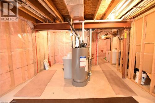 Unfinished below grade area featuring water heater, a water softener, and washing machine and dryer - 52 Meadowridge Street, Kitchener, ON - Indoor Photo Showing Basement