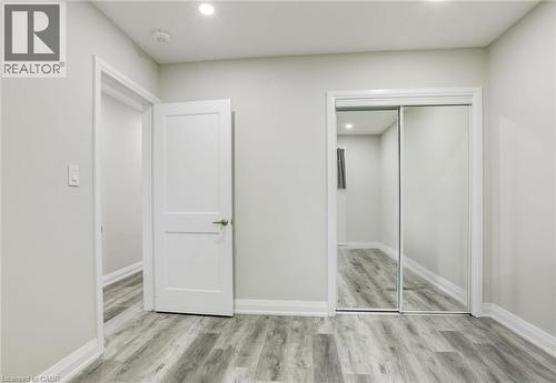 Unfurnished bedroom featuring light wood-style flooring, recessed lighting, and a closet - 7 Cardill Crescent, Waterloo, ON - Indoor Photo Showing Other Room