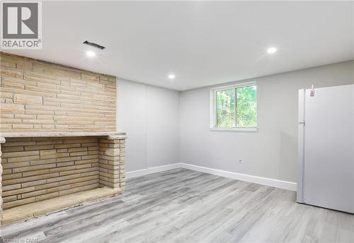 Below grade area with freestanding refrigerator, light wood-type flooring, and recessed lighting - 7 Cardill Crescent, Waterloo, ON - Indoor Photo Showing Other Room