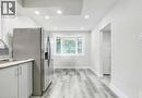 Kitchen with light countertops, stainless steel refrigerator with ice dispenser, light wood-style flooring, white cabinetry, and recessed lighting - 7 Cardill Crescent, Waterloo, ON  - Indoor Photo Showing Kitchen With Double Sink 