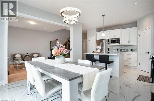 Dining area featuring a chandelier and light marble finish flooring - 346 Chokecherry Crescent, Waterloo, ON - Indoor Photo Showing Dining Room