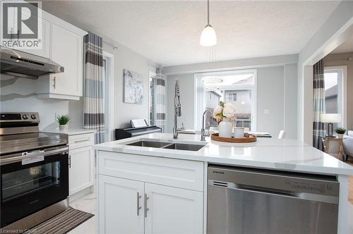 Kitchen with stainless steel appliances, white cabinets, light stone countertops, and a kitchen island with sink - 346 Chokecherry Crescent, Waterloo, ON - Indoor Photo Showing Kitchen With Double Sink With Upgraded Kitchen