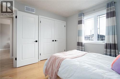 Bedroom with light wood-style flooring, a closet, and a textured ceiling - 346 Chokecherry Crescent, Waterloo, ON - Indoor Photo Showing Bedroom
