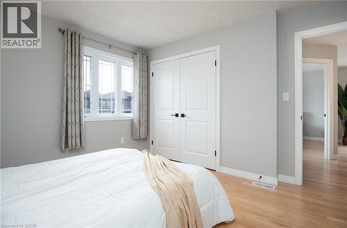 Bedroom with light wood-style floors, a textured ceiling, and a closet - 346 Chokecherry Crescent, Waterloo, ON - Indoor Photo Showing Bedroom