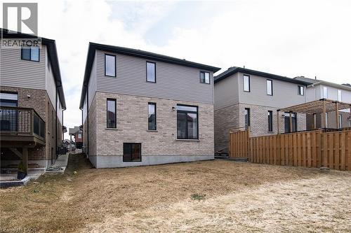 Back of property with brick siding, a lawn, and a wooden deck - 346 Chokecherry Crescent, Waterloo, ON - Outdoor With Exterior