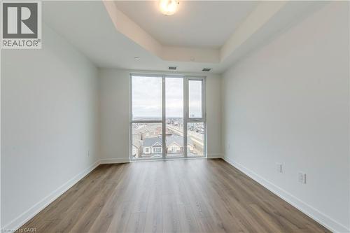 Unfurnished room featuring a tray ceiling and wood finished floors - 770 Whitlock Avenue Unit# 606, Milton, ON - Indoor Photo Showing Other Room