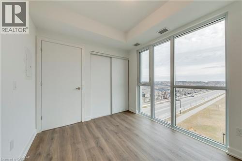 Unfurnished bedroom with light wood-type flooring, a closet, and electric panel - 770 Whitlock Avenue Unit# 606, Milton, ON - Indoor Photo Showing Other Room