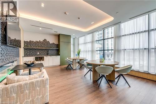 Dining room with light wood-style flooring, a raised ceiling, and floor to ceiling windows - 770 Whitlock Avenue Unit# 606, Milton, ON - Indoor
