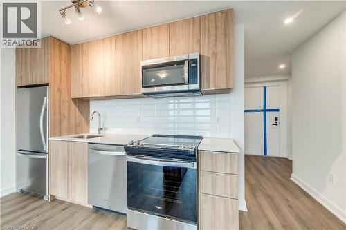 Kitchen featuring modern cabinets, stainless steel appliances, light stone counters, light wood finish cabinets, and recessed lighting - 770 Whitlock Avenue Unit# 606, Milton, ON - Indoor Photo Showing Kitchen