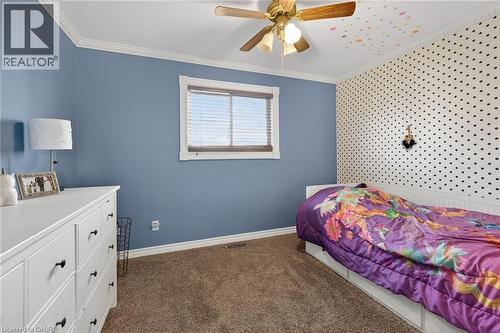 Bedroom featuring ornamental molding, dark colored carpet, and a ceiling fan - 703 Dunn Avenue, Hamilton, ON - Indoor Photo Showing Bedroom