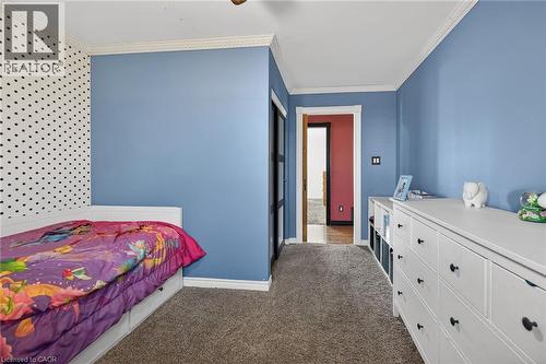 Bedroom with crown molding, dark carpet, and a ceiling fan - 703 Dunn Avenue, Hamilton, ON - Indoor Photo Showing Bedroom