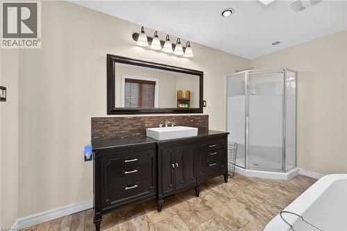 Full bathroom featuring a shower stall, vanity, a soaking tub, and tasteful backsplash - 703 Dunn Avenue, Hamilton, ON - Indoor Photo Showing Bathroom