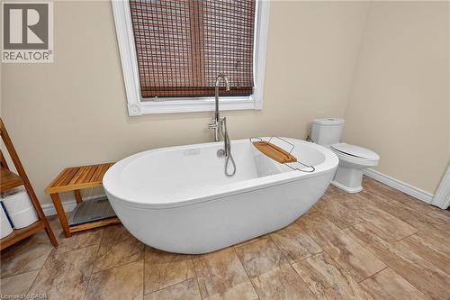 Bathroom with a soaking tub and toilet - 703 Dunn Avenue, Hamilton, ON - Indoor Photo Showing Bathroom