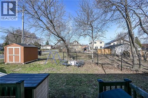 Fenced backyard with a storage unit, a residential view, and a playground - 703 Dunn Avenue, Hamilton, ON - Outdoor