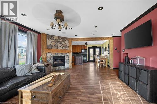 Living area featuring a fireplace, crown molding, dark wood-type flooring, and ceiling fan - 703 Dunn Avenue, Hamilton, ON - Indoor Photo Showing Living Room With Fireplace