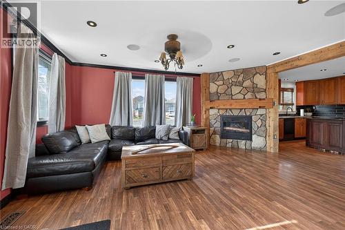 Living area with healthy amount of natural light, dark wood-style flooring, a fireplace, a ceiling fan, and recessed lighting - 703 Dunn Avenue, Hamilton, ON - Indoor Photo Showing Living Room With Fireplace