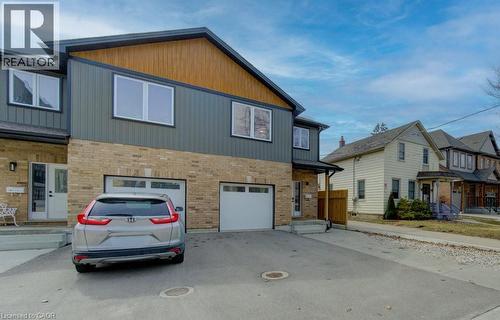 View of front of property with an attached garage, driveway, and brick siding - 113 Walter Street, Kitchener, ON - Outdoor