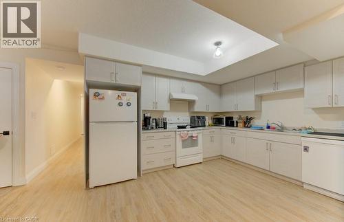Kitchen featuring white appliances, light wood-style flooring, light countertops, and white cabinetry - 113 Walter Street, Kitchener, ON - Indoor Photo Showing Kitchen