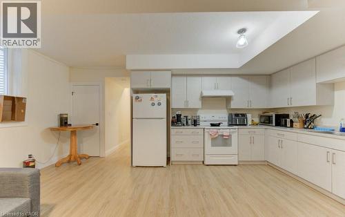 Kitchen featuring white appliances, light wood finished floors, light countertops, and white cabinetry - 113 Walter Street, Kitchener, ON - Indoor Photo Showing Kitchen With Double Sink