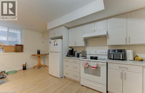 Kitchen featuring white appliances, light countertops, light wood-style floors, and white cabinetry - 113 Walter Street, Kitchener, ON - Indoor Photo Showing Kitchen