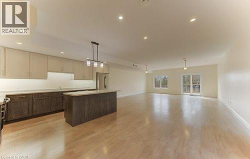 Kitchen featuring light countertops, a kitchen island, open floor plan, light wood-type flooring, and freestanding refrigerator - 113 Walter Street, Kitchener, ON - Indoor Photo Showing Kitchen