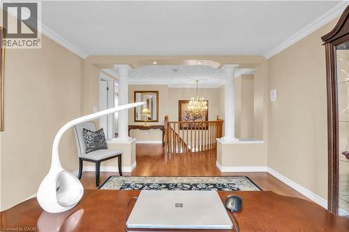Living area with crown molding, light wood-type flooring, suspended lighting, an upstairs landing, and decorative columns - 228 Michener Crescent, Kitchener, ON - Indoor Photo Showing Other Room