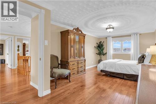 Bedroom featuring ornamental molding, light wood-style flooring, and a textured ceiling - 228 Michener Crescent, Kitchener, ON - Indoor Photo Showing Bedroom