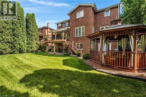 Back of property featuring a wooden deck, a gazebo, a patio area, brick siding, and a lawn - 228 Michener Crescent, Kitchener, ON - Outdoor With Deck Patio Veranda