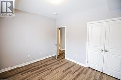 Unfurnished bedroom featuring dark wood-type flooring and a closet - 