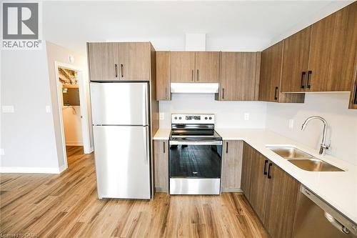 Kitchen featuring stainless steel appliances, wood finish cabinetry, light wood-type flooring, and modern cabinets - 40 Pietz Avenue, Welland, ON - Indoor Photo Showing Kitchen With Double Sink With Upgraded Kitchen