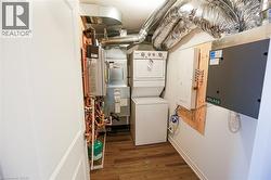 Laundry room featuring dark wood-style floors and stacked washer / drying machine - 