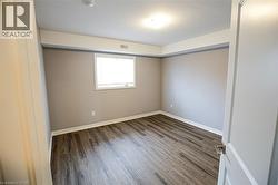 Empty room with dark wood-style flooring and baseboards - 