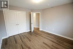 Unfurnished bedroom with a closet and dark wood-style flooring - 