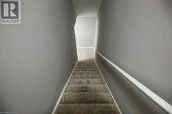 Stairway featuring baseboards and carpet floors - 