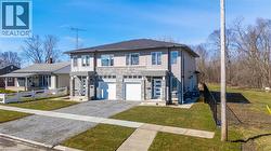 View of front of property featuring a garage, gravel driveway, and stone siding - 