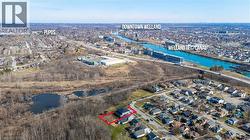View of property location featuring a large body of water, nearby suburban area, and property parcel outlined - 